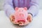 Close-up Of Businessman\'s Hand Holding Piggybank Over White Background.