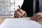 Close up businessman signing contract, holding pen, filling form