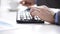 Close up of businessman typing and drinking coffee