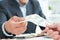 Close-up of businessperson taking bribe from partner on wooden desk. Just hands over the table.