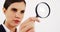 Close-up of businesswoman looking through magnifying glass