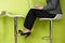 Close Up Of Businesswoman Sitting On Stool Using Laptop