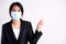 Close up of a businesswoman in a suit wearing Protective face mask pointing to free space, get ready for Coronavirus and pm 2.5