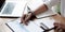 Close-up A businesswoman works on a financial chart report, calculates business costs and profits, and sits at her desk