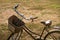 Close-up of bycicle with basket standing on ground.