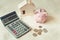 Close-Up of Calculator, Piggy Bank, Money Coin and Housing Model on The Bedroom, Business Banking and Financial Savings Concept