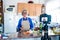 Close up of camera filming a mature woman or senior cooking and doing live or video for her social networks and medias -