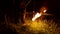 Close-up. Camera follows man in the dark with a burning ball, poi. Fire show