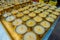 Close up of candels inside of a golden goblets over ametallic tray in a table with a view of Boudhanath Stupa building