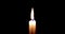 Close-up of candle burn with glow flame fire sparkle on black background, with copy space for text, holiday