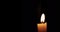 Close-up of candle burn with glow flame fire sparkle on black background, with copy space for text, holiday event