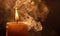 Close-up of a candle with wisps of smoke rising from the flame