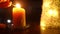 Close-up candles in darkness on table with female hand lighting up with match. Closeup unrecognizable Caucasian young