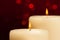 Close-up of candles with flame on red bokeh