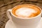 Close up cappuccino in white cup on wood table background at cafe. Bewerages, coffee lovers and morning menu concept