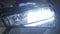 Close-up of car headlight turning on and off. Car dealership, auto repair shop, automotive industry.