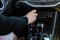 Close up of the car interior, a female hand sets the temperature for the air condensing system