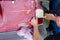 Close up of a car mechanic applying msking tape to a sanded down car before a paint job in the body shop