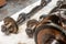 Close-up on a car shaft with gears and bearings removed for replacement on a workbench in a repair shop for vehicles. Auto service