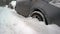Close up of car wheels stuck in snow drift.