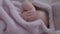 Close-up carefree sleeping baby girl rubbing eyes with little hand. Portrait of charming Caucasian adorable infant lying