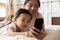 Close up caring Asian mother and little girl using smartphone