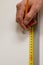 Close up of carpenter hands marks the furniture with a tape measure and a pencil