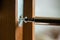 Close up of carpenter repairing door lock. Installing a door handle. Handyman tightening door hinge . Hands of the repairman with