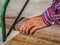 close up of Carpenter sawing a board with a hand wood saw. profession, carpentry, woodwork and people concept.