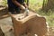 Close up of a carpenter scrubbing wood chair with handheld electric scrubber