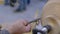 Close up: carpenter using chisel for shaping piece of wood on lathe: slow motion