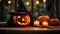 Close up of a carved and glowing Pumpkin with a Witch Hat on a wooden Table standing beside a Candle. Scary Halloween Backdrop.