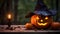 Close up of a carved and glowing Pumpkin with a Witch Hat on a wooden Table standing beside a Candle. Scary Halloween Backdrop.