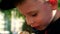 Close up of a Caucasian boy of preschool age with an appetite eats a sandwich on the street.