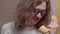 Close-up of Caucasian curly-haired man in eyeglasses holding retro telephone handset and talking. Portrait of smart nerd