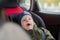 Close Up caucasian cute baby boy woke up and yawns in modern car seat. Child traveling safety on the road. Safe way to