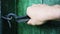 Close-up of a caucasian man\'s hand closes a wooden door in a house locked on a hook.