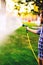 Close up of caucasian man watering backyard lawn using hosepipe