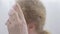 Close-up of Caucasian mid-adult woman looking at her hair. Portrait of sad senior lady feeling aging. Femininity