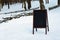 Close up of chalkboard menu outside on the snow. Winter menu display in the mountains