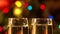 A close up of champagne glasses with colourful light on the background