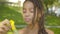 Close-up of charming happy African American girl blowing soap bubbles in sunny summer park. Portrait of joyful child or