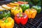 close-up of charred bell peppers and zucchini on grill grates
