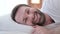 Close Up of Cheerful Beard Young Man Smiling at Camera in Bed