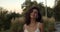 Close up of cheerful brunette woman with wavy hair smiling while walking outdoors. Portrait of playful latino female