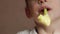 Close-up of a cheerful Caucasian preschooler boy blowing a paper festive pipe. Child`s birthday. Happy child with a festive tune.