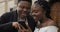 Close up of cheerful couple looking at smartphone screen and laughing. Young african couple standing outdoors using