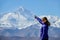 CLOSE UP: Cheerful female traveler points at the windswept peak of Mount Everest