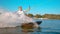 CLOSE UP: Cheerful young surfer wakeboarding and splashing water into the camera