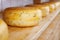 Close-up of cheese-wheels maturing on shelves